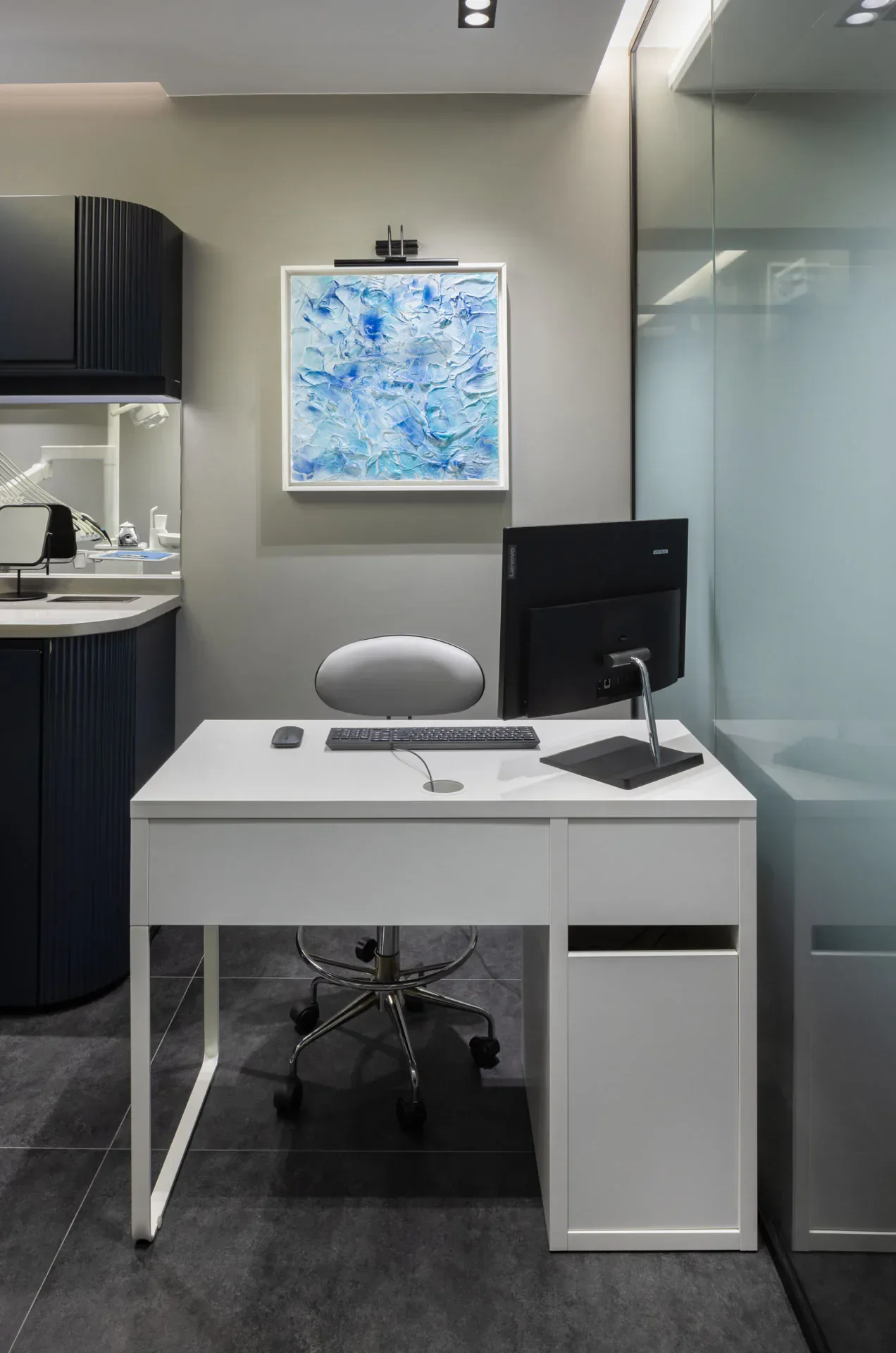 Consultation desk with a screen and a blue painting on the wall