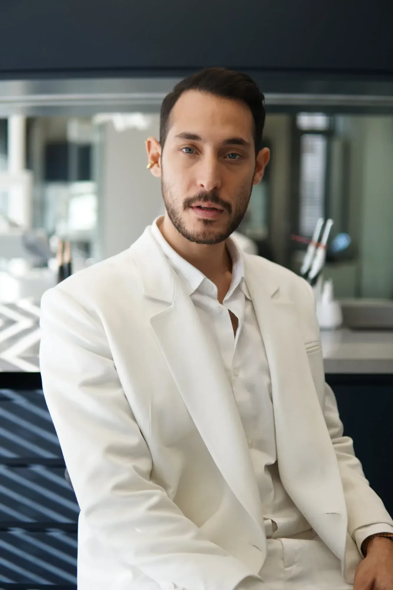 Dt. Doğa Erginoğlu seated in the practice, wearing a white suit